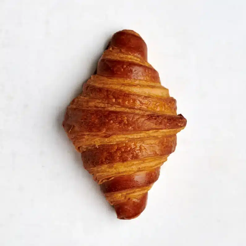 Plain croissant with a golden, flaky exterior and soft, buttery interior, perfect for a classic breakfast treat