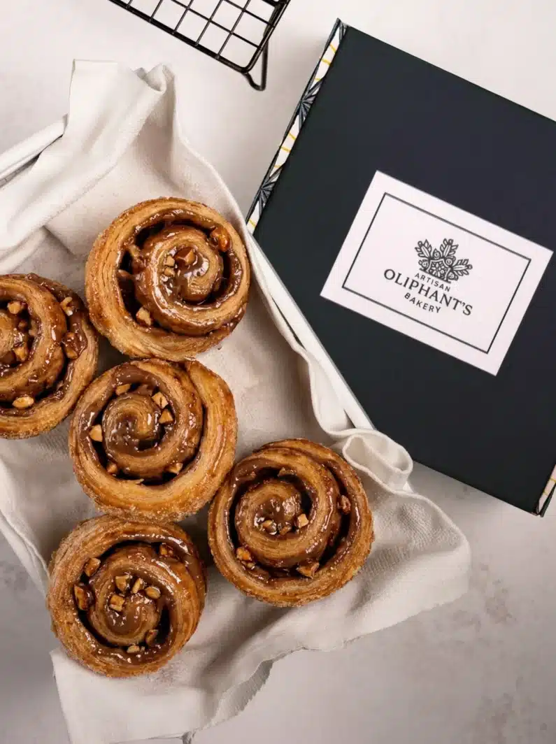 Indulgent milk chocolate, honey, and almond bun in a small bakery box, combining rich flavours in a perfect treat