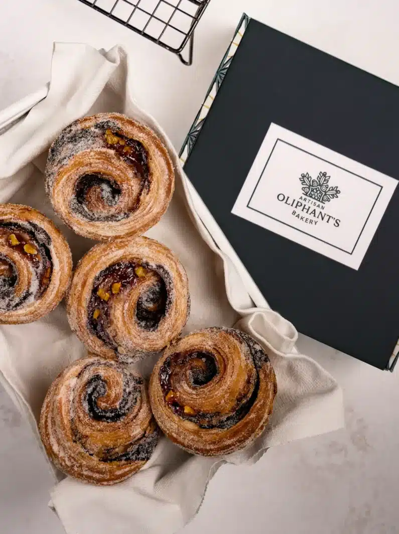 Rich dark chocolate and zesty orange pastries in a small bakery box, a perfect combination of flavors for gifting or indulgence